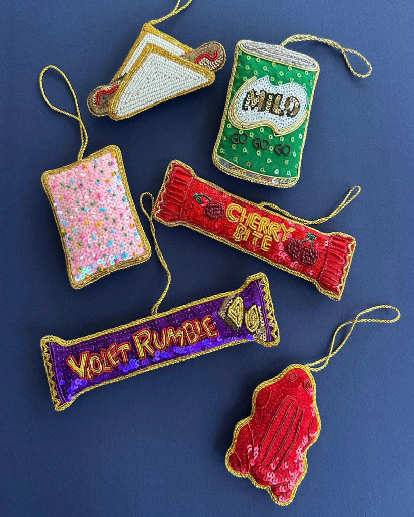 Collection of colorful embroidered food item ornaments on a blue background