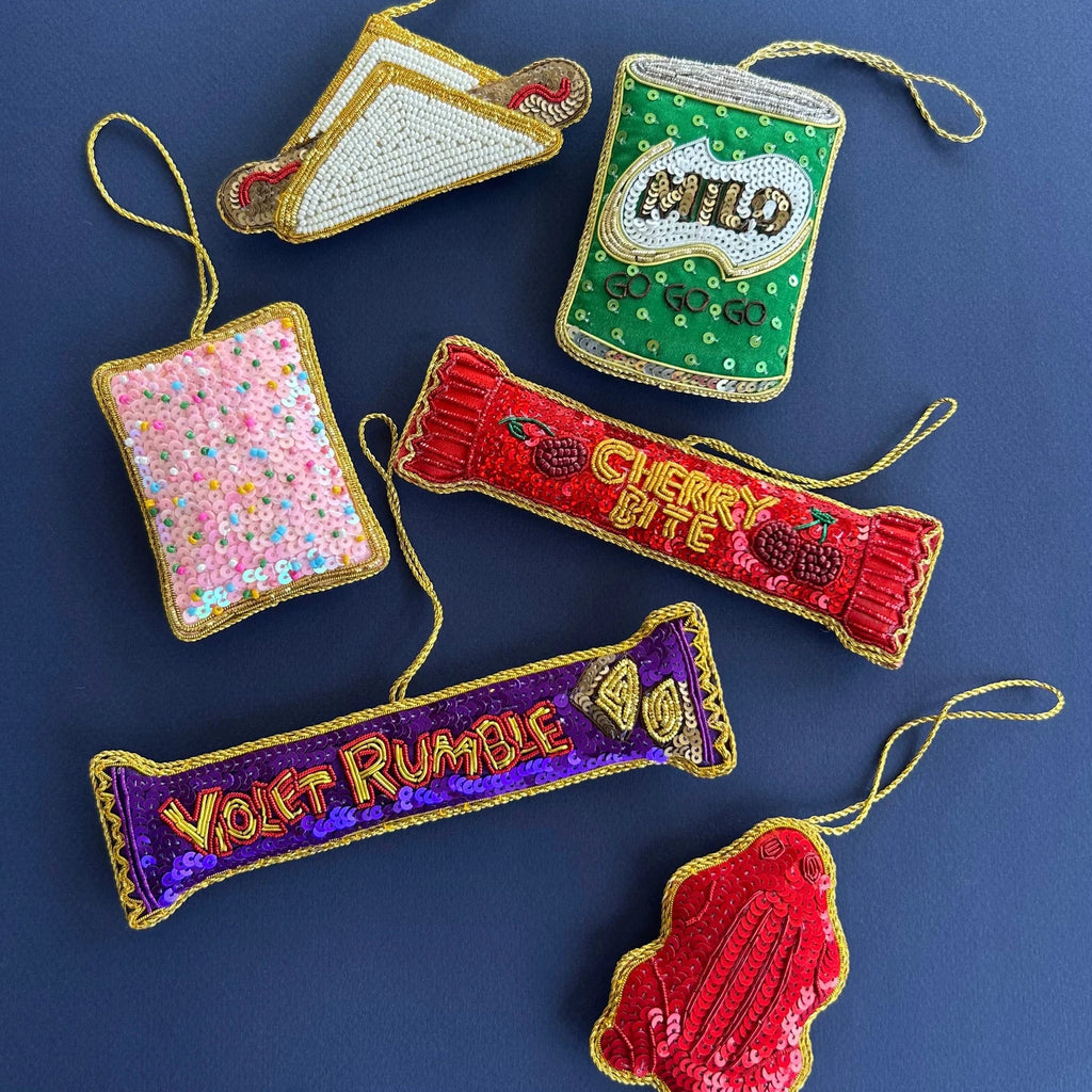 Collection of embroidered food item ornaments on a blue background