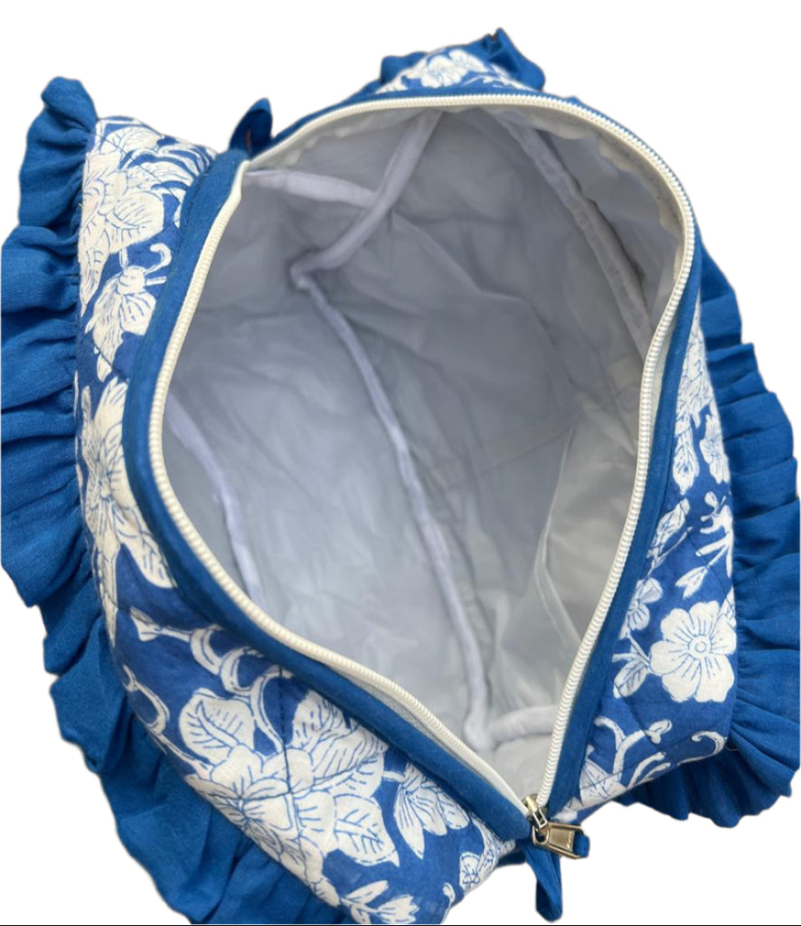 Blue floral-patterned bag with a zipper on a natural background