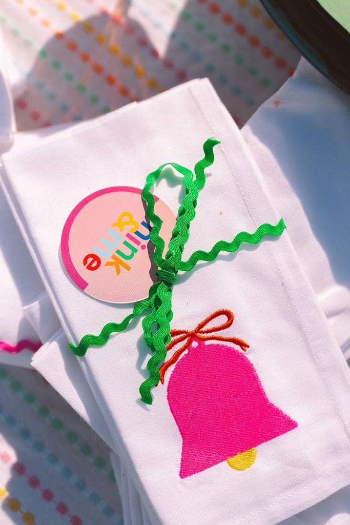 White fabric with colorful embroidered design on a polka dot background